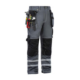 Side view of B114 100% cotton work pants with knee pads, hanging tool pockets filled with tools, and reflective stripes